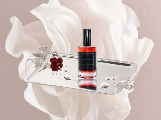 30ml Southern Coastal Y Parfum bottle on silver tray with cherries and water droplets against soft white fabric background